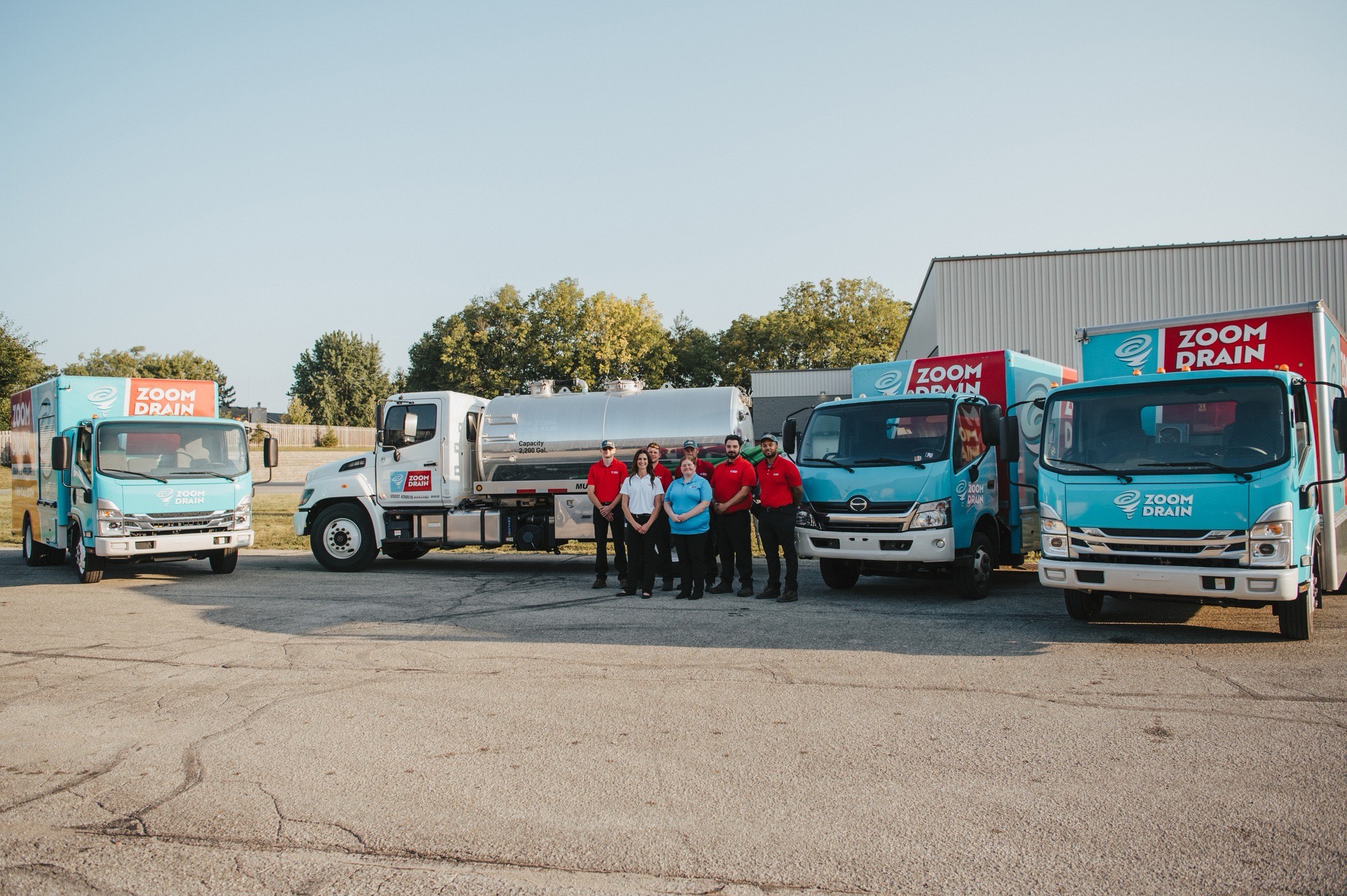 team in front of zoom drain truck fleet